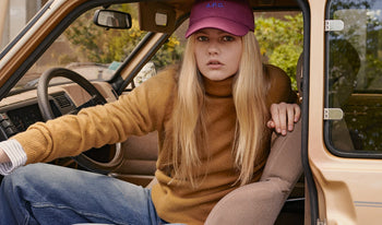 A.P.C. Women Jumpsuits - Woman wearing camel sweater sitting in car.