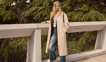 A.P.C. Women Sale T-shirts, Tops - Woman standing on bridge in coat and jeans.