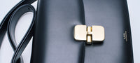 Focus on a A.P.C. bag and its golden buckle