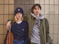 Woman and man model wearing A.P.C. FW24 Collection embracing against a tile wall