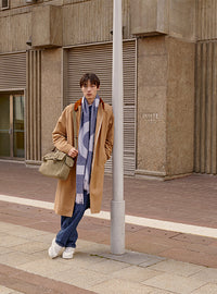 A.P.C. Men - Man wearing coat and scarf standing in front of university building.