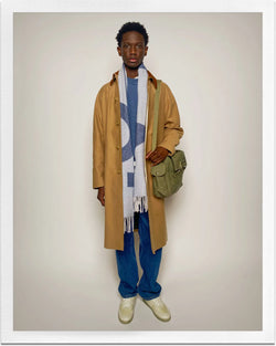 A.P.C. Journal - Man wearing beige coat and blue jeans with scarf.