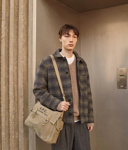 A.P.C. Fall/Winter Campaign - Man standing in front of a door wearing collegiate clothing.